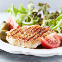 Grilled Turkey Breast with fresh salad. Bright background.	