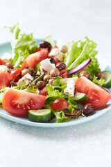 Healthy and tasty salad with feta cheese, various tomatoes, olives, cucumber, onion and lettuce.