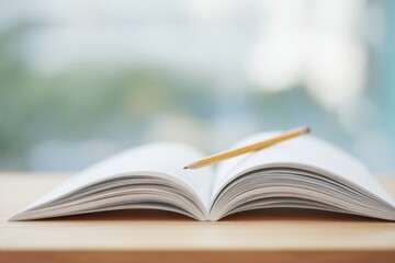 close-up of open book on wooden desk with pencil resting above symbolizing higher education