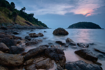 Scenic Coastal Landscape with Rocky Shoreline and Distant Island at Sunset..