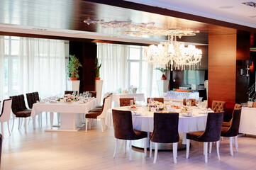 Elegant Restaurant Interior with Chandelier and Table Settings for Special Occasion..