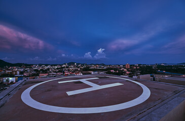 Rooftop Helipad Overlooking Urban Landscape at Twilight..