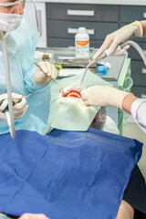Dental professionals perform a procedure on a patient while ensuring safety and comfort in a clinical setting