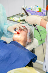 Dental professional performs cleaning procedure on a patient to remove plaque, ensuring dental...