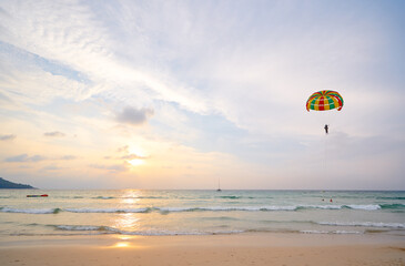 Parasailing Adventure Over Calm Ocean at Sunset with Relaxing Beach View..