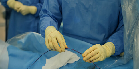 Interventional radiologist performing minimally invasive procedure with precision microcatheter in sterile medical environment