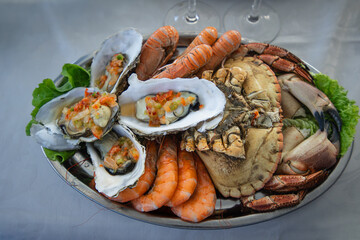 An appetizing seafood platter featuring fresh, succulent oysters, sweet crabs, and plump prawns, ready to be enjoyed. Perfect for culinary and food related projects.