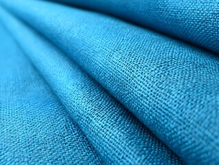 Turquoise Textile: The image showcases a close-up view of elegantly folded turquoise fabric, revealing the textures and patterns of the textile, creating a sense of depth and tactile beauty.