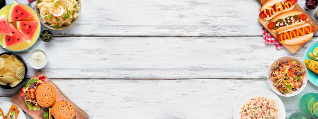 Summer food table scene with hot dogs, hamburger and sides. Above view double border over a white wood banner background. Copy space.