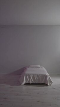Lit isol&eacute; dans une pi&egrave;ce vide avec lumi&egrave;re violette ambiante

