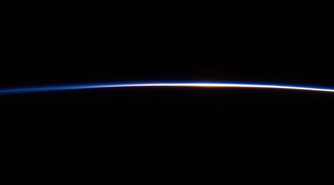 Earth's limb, a thin, luminous line against the inky void of space