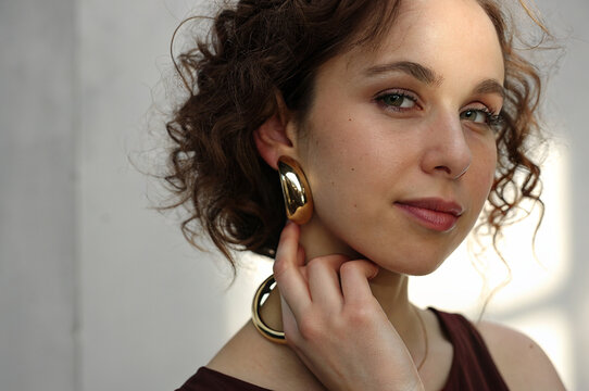 Woman with gold hoop earrings - Powered by Adobe