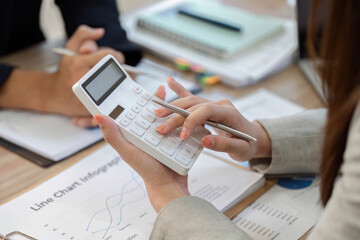 Calculator Usage in Financial Analysis. Professional woman calculating data during a meeting.