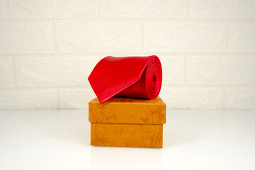 A red tie rolled on gift box closeup view 