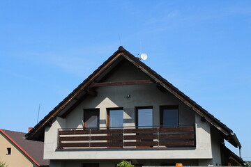 White modern big family house with red tilled roof against blue sky background
