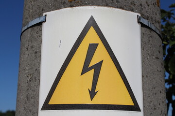 Danger sign of high voltage electricity. Yellow triangular label with a zipper in the center on the...