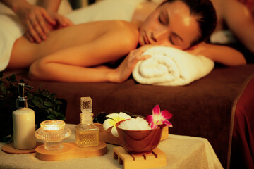 Obraz na płótnie Canvas Caucasian couple customer enjoying relaxing anti-stress spa massage and pampering with beauty skin recreation leisure in warm candle lighting ambient salon spa at luxury resort or hotel. Quiescent