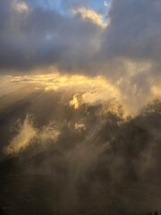 Pico do Arieiro bathed in golden sunlight as soft clouds drift across the peaks, creating a warm, serene moment high above the island of Madeira.