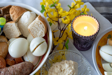 A festive table with traditional foods and a candle, creating a warm ambiance for gatherings