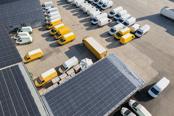 Delivery vans and trucks hub with solar panels on a roof. Fleet of vehicles