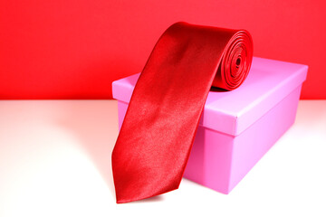 red tie rolled on gift box closeup view 