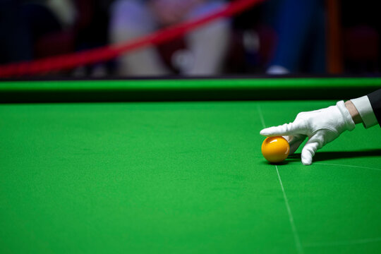 A snooker referee places balls on the table with pinpoint accuracy