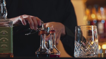 Closeup hand bartender holding jigger to measure liquor sugar into mixing glass ingredients alcohol preparation creative mixed cocktail. Special refresh drink showcasing nightlife mixology. Vinosity.