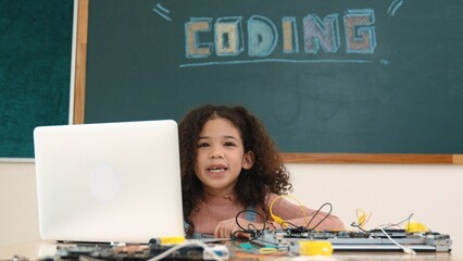 Attractive african student programing system while looking at camera. American girl working on her...