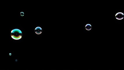 Small iridescent bubbles floating on a black background - Powered by Adobe