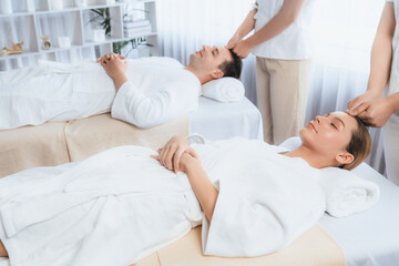 Obraz premium Caucasian couple enjoying relaxing anti-stress head massage and pampering facial beauty skin recreation leisure in dayspa modern light ambient at luxury resort or hotel spa salon. Quiescent