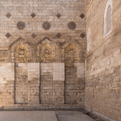 Fototapeta premium The Mosque of al-Zahir Baybars stands majestic in Cairo, Egypt, showcasing intricate stonework and architectural details under soft golden hour light