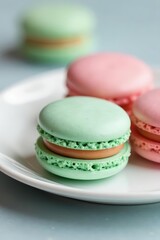 Obraz premium Pastel French macarons, soft focus, white plate, delicate, closeup, tasty