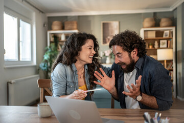 Excited couple sharing pregnancy test result on video call at home
