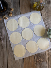Top view of a wooden table with the ingredients arranged to cook some vegetarian dumplings