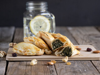 Plate of freshly made vegetable dumplings, a half-open dumpling with the contents in view, nuts as...