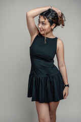 Portrait of a beautiful teenage girl in a black dress. Three-Quarter Body portrait. .