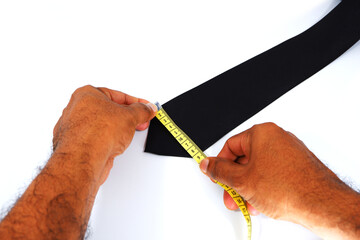 black tie size measurement taking by human hands closeup shot on white background, necktie measuring based concept  