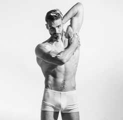 Handsome guy in boxer shorts washing body with moisturizing shower gel. Morning routine, self...