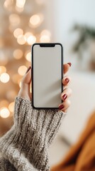 A woman holding a smartphone with a blank screen against a blurred background of bokeh lights