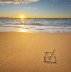 Plakat Check mark symbol in box on the beach shore during the sunset.