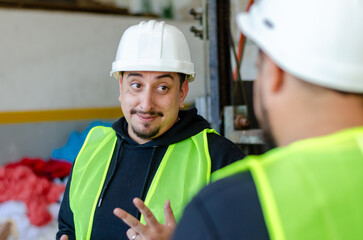 Smiling portrait of two males workers industry or engineer holding a digital tablet and wearing...