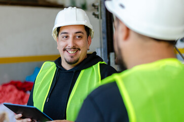 Smiling portrait of two males workers industry or engineer holding a digital tablet and wearing safety gear. Recycle concept