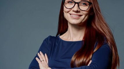 Woman emerging from behind leaves and smiling confidently in blue outfit