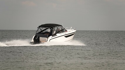 Płynąca łódź rozbijająca fale © tomo81