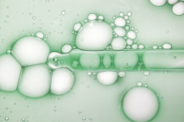 Liquid green ampoule or serum with pipette dropper background. Cosmetic skincare beauty product texture sample swatch