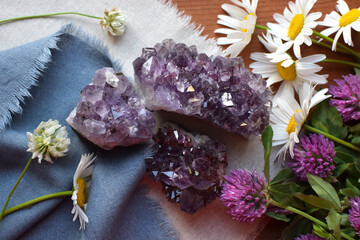 Beautiful natural amethyst druse stones with chamomile flowers. Healing crystals. Precious purple...
