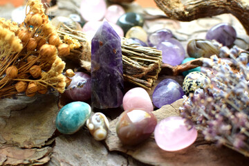 Beautiful natural stones, amethyst obelisk and dry herbs on wooden background. Healing crystals....