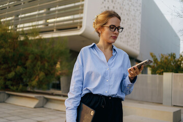 A Young Professional Woman is Utilizing Her Smartphone While Outside in an Urban Setting