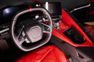 Closeup of a modern car steering wheel with control buttons for technology and convenience