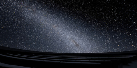 Starry sky viewed from inside a planetarium with rows of seats visible; concept: astronomy, stargazing, exploration